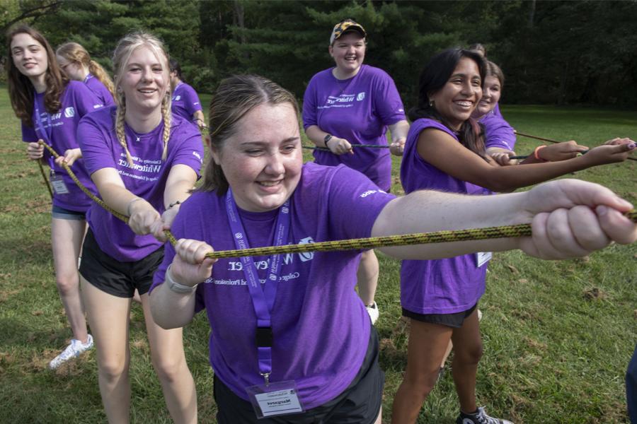 Future teachers wear purple shirts as they do tug of war as a leadership exercse.